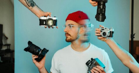 Photographer being handed a different kind of cameras