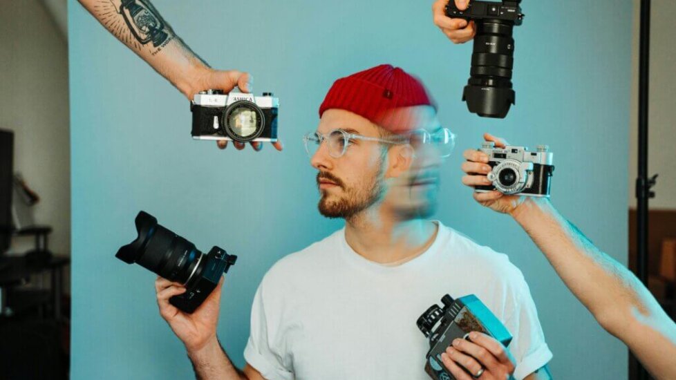 Photographer being handed a different kind of cameras