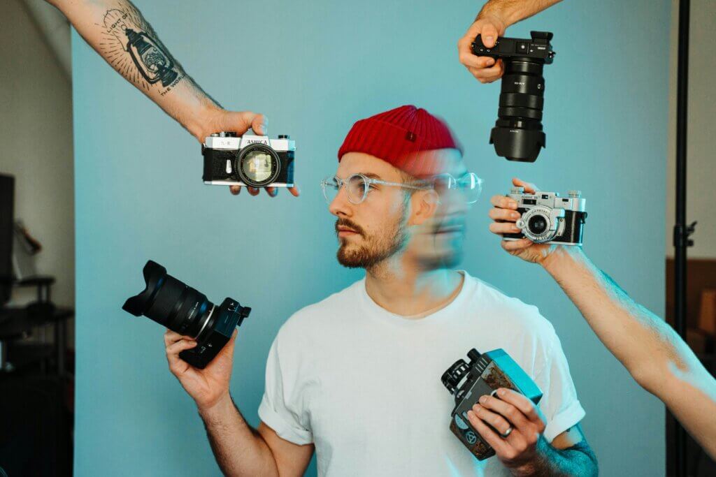 Photographer being handed a different kind of cameras